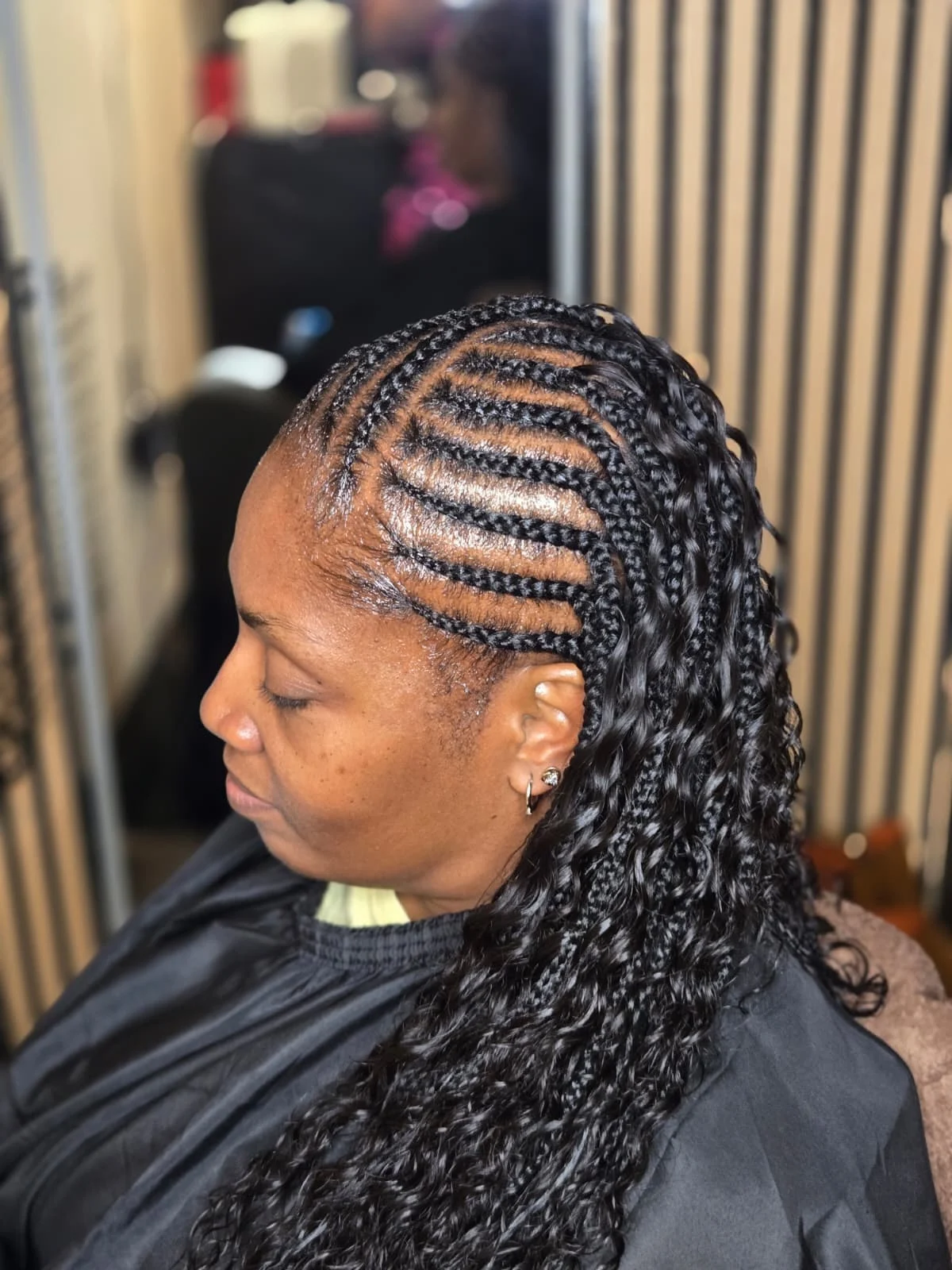 Side profile of Fulani cornrows flowing into long boho curls